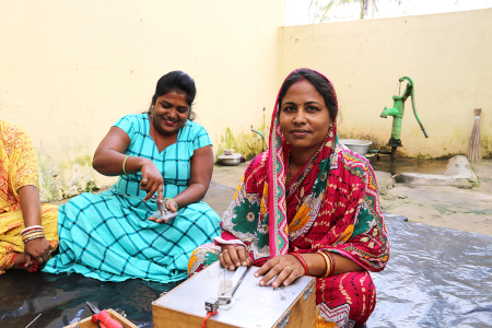 Eine Frau in Indien erstellt mit der Biegemaschine eine Brille