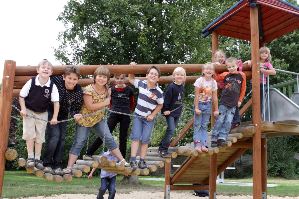 Viele Kinder stehen auf der Hängebrücke eines großen Spielgerätes