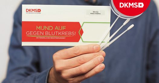 Ein Mann hält den Testkit, bestehend aus einer Karte und Teststäbchen in der Hand