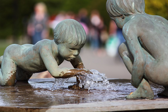 Ein Brunnen auf dem zwei kindliche Figuren nach Wasser greifen.